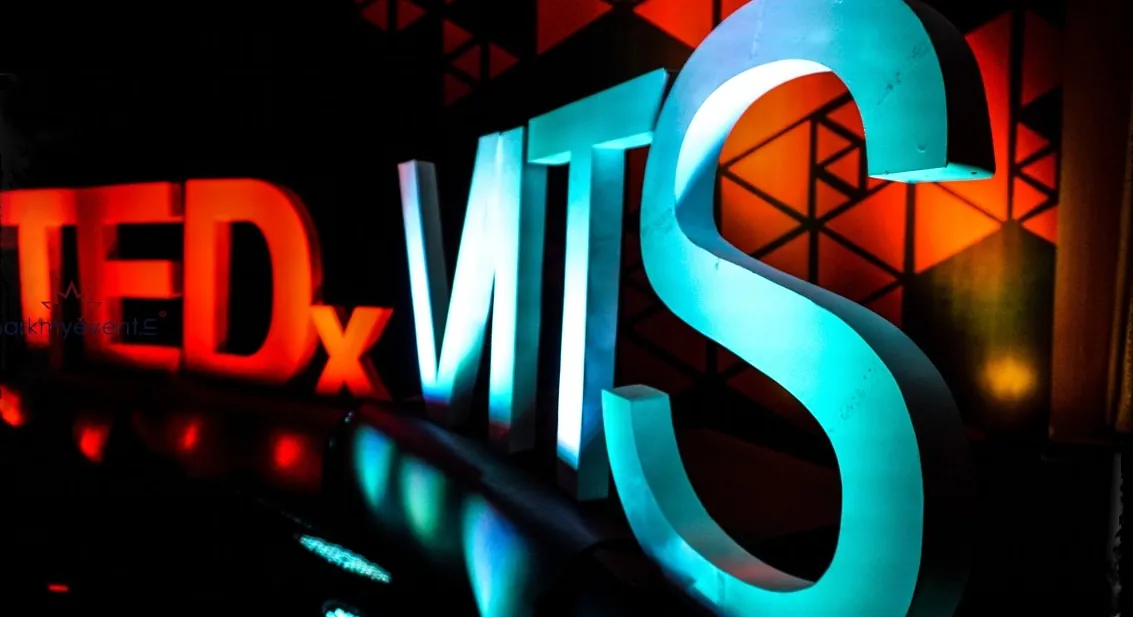 Glowing TEDxVITS lettering on a conference stage